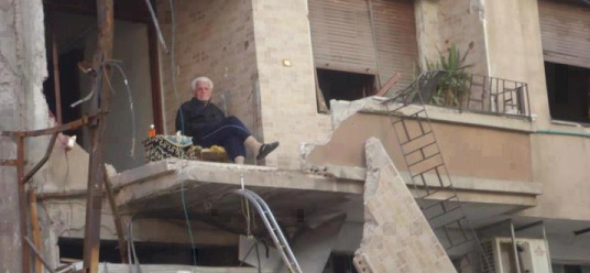 Syrian man drinking tea after his house was bombed