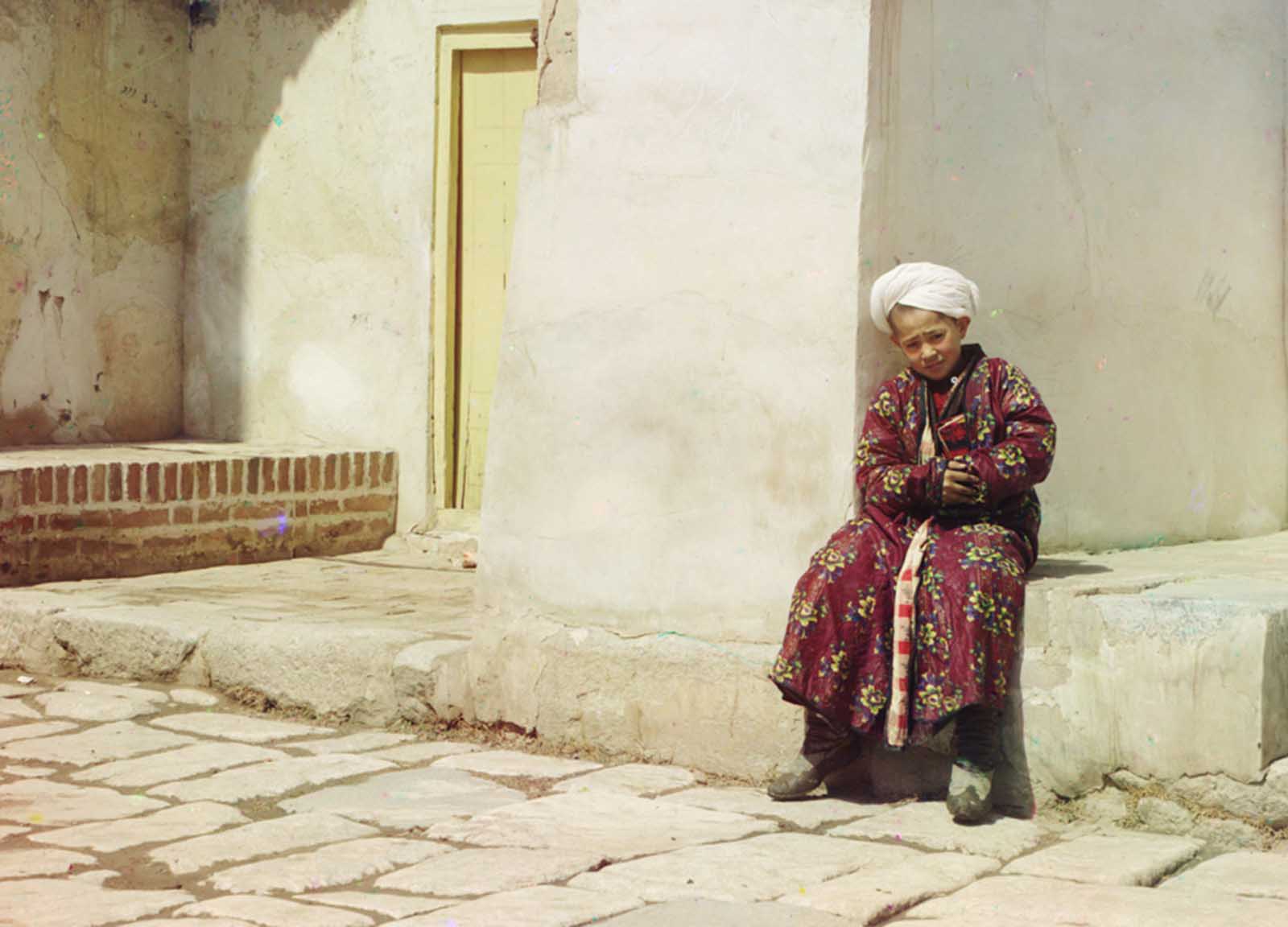 A boy sits in the court of Tillia-Kari mosque in Samarkand, present-day Uzbekistan, ca. 1910.