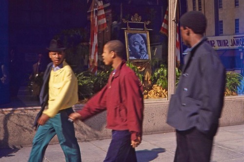 Three young men walk past Martin Luther King, Jr. portrait displayed in the storefront window of Woodward & Lothrop April 6, 1968